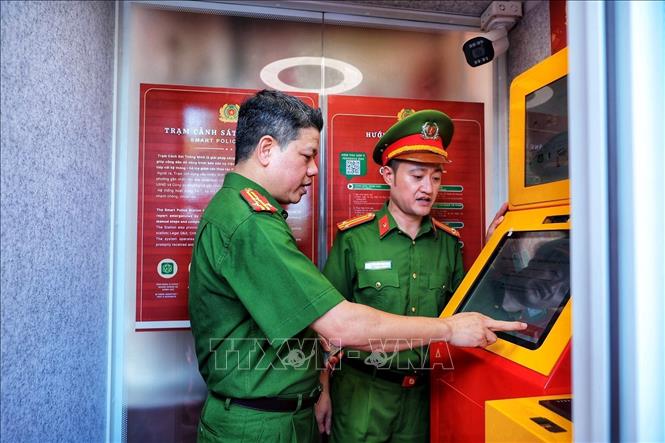 Thượng tá Nguyễn Thành Lâm (bên trái) cùng cán bộ Công an trải nghiệm hoạt động của Kiosk “Trạm Cảnh sát thông minh” trước khi đưa vào phục vụ người dân. (Ảnh: Phạm Tuấn Anh/TTXVN)